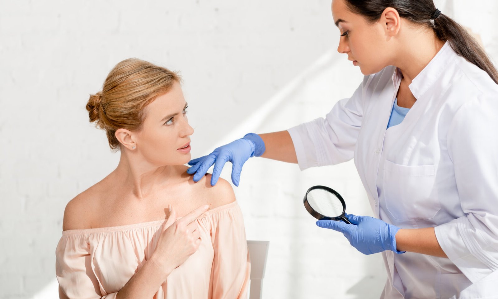 Dermatóloga examinando la piel de una paciente