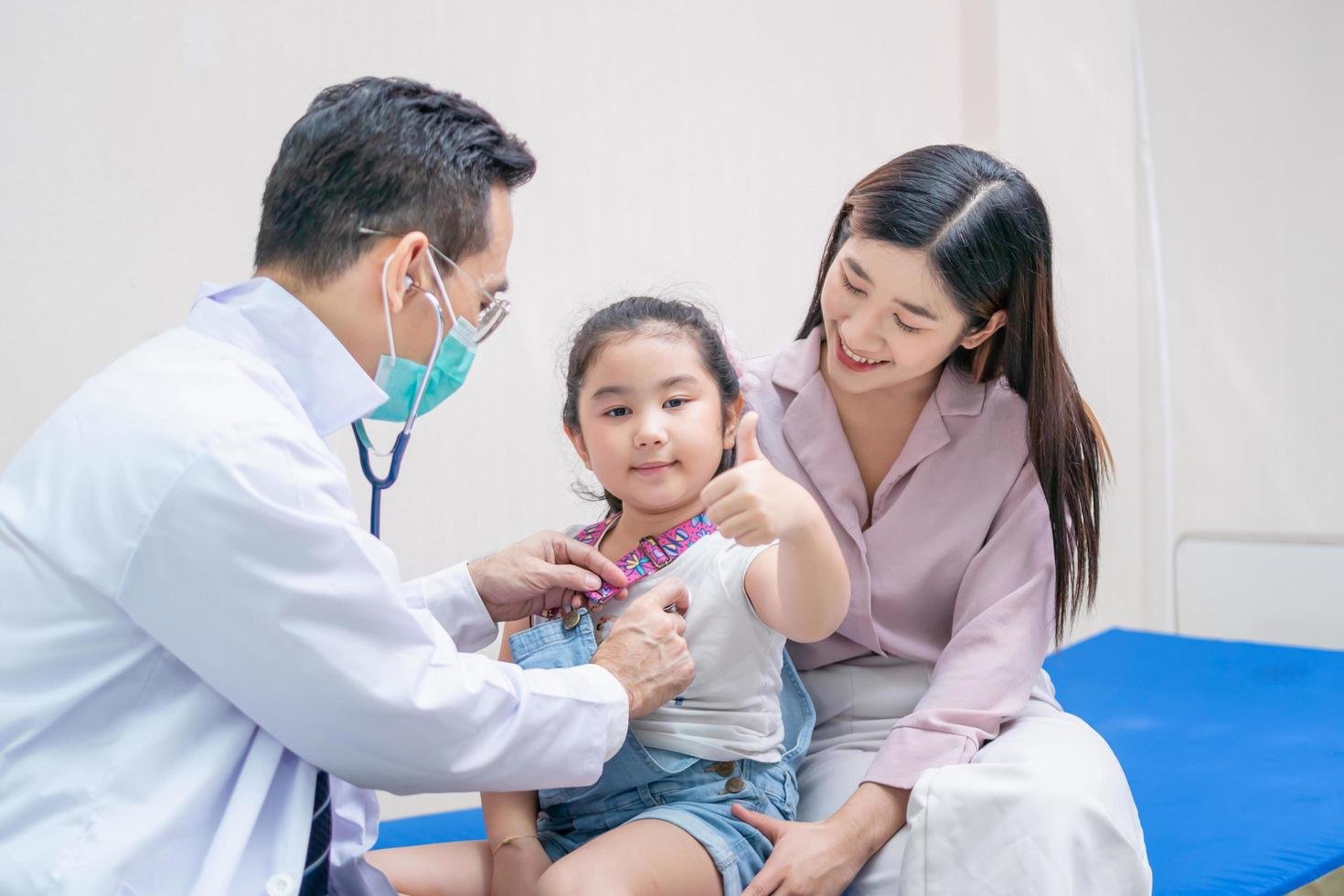 Pediatra examinando a una niña acompañada por su madre